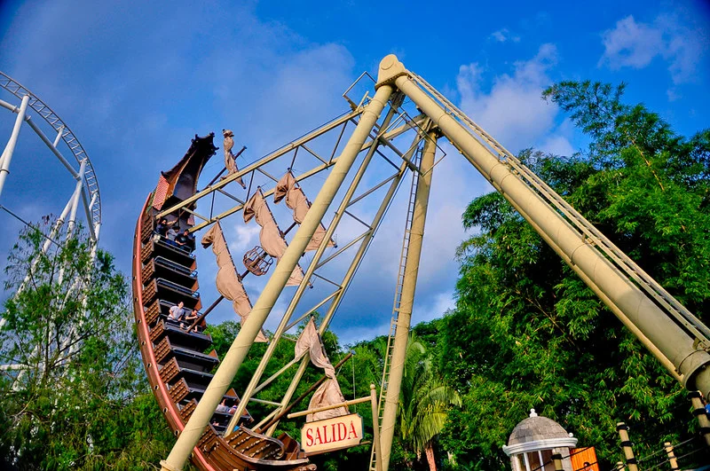 Turistas disfrutando del juego mecánico del barco pirata en el parque temático Xetulul, una atracción principal a solo 5 minutos de nuestro alojamiento.