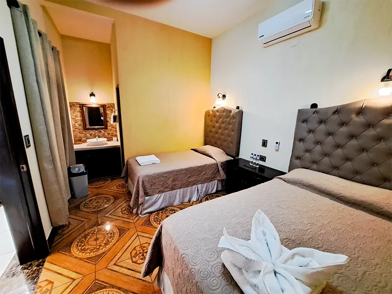 Habitación doble limpia con una cama matrimonial y una cama imperial y aire acondicionado en Hotel La Mansión del Gran Jaguar, San Felipe.